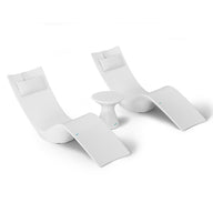 The Resort Luxury Outdoor Paradise In-Pool Furniture Bundle by Ledge Lounger features two modern white chaise loungers with headrests, spaced slightly apart. A small round white side table is centrally positioned, creating an ideal poolside relaxation spot against a plain white backdrop.