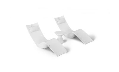 The Resort Luxury Outdoor Paradise In-Pool Furniture Bundle by Ledge Lounger features two modern white chaise loungers with headrests, spaced slightly apart. A small round white side table is centrally positioned, creating an ideal poolside relaxation spot against a plain white backdrop.