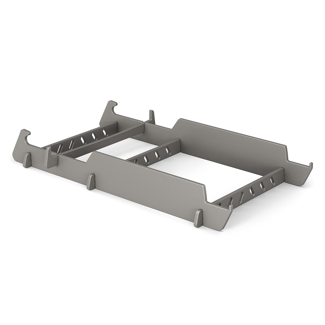 A gray metal server rack mount bracket with angled edges is designed to hold equipment securely, similar to the precision of a Signature Lowback Chair Riser by Ledge Lounger. It features multiple cutouts and slots for adjustable fitting, all set against a white background.