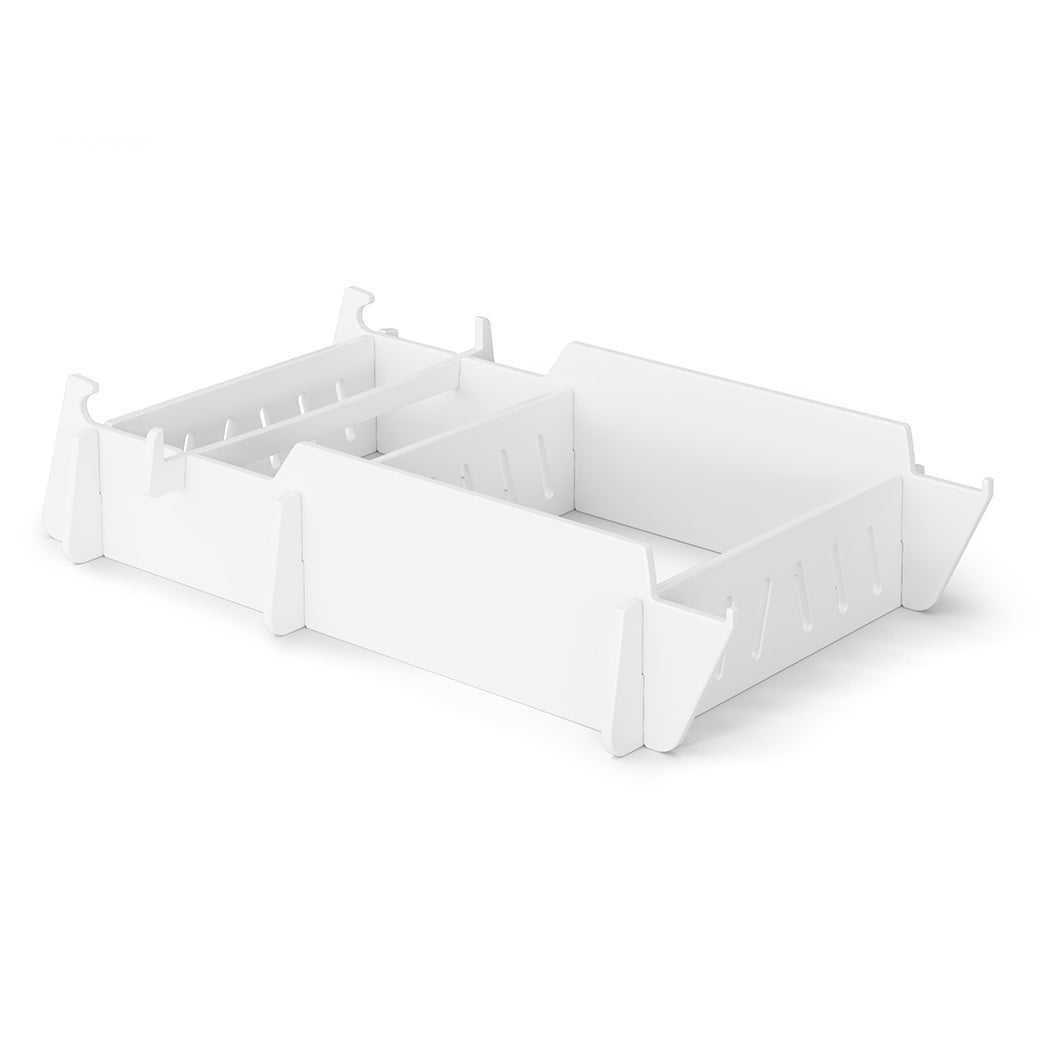 The white adjustable drawer organizer with slotted dividers and a minimalist design sits on a plain background, its simplicity echoing the elegance of Ledge Loungers Signature Lowback Chair Riser, ideal for organizing essentials on an outdoor day.