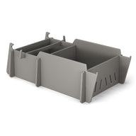 The Ledge Lounger Signature Lowback Chair Riser is a gray modular storage box with three compartments and detachable panels. It features side slots for ventilation, an interlocking system for stacking, and is perfect for outdoor use or by pool seats, set against a plain white background.