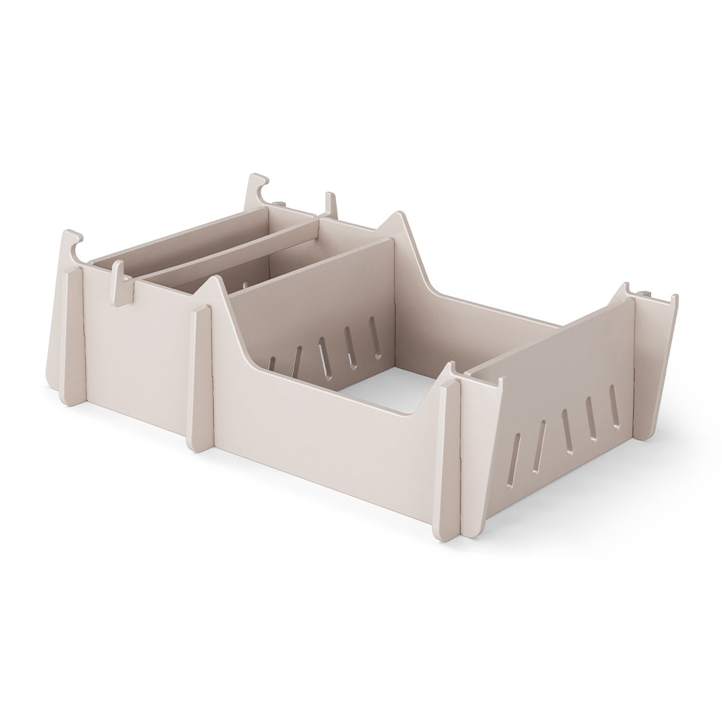 A beige, rectangular plastic organizer with two compartments and side slots features raised sides and hooks for stacking, resembling the Signature Chair Riser by Ledge Lounger. Its showcased on a plain white background.