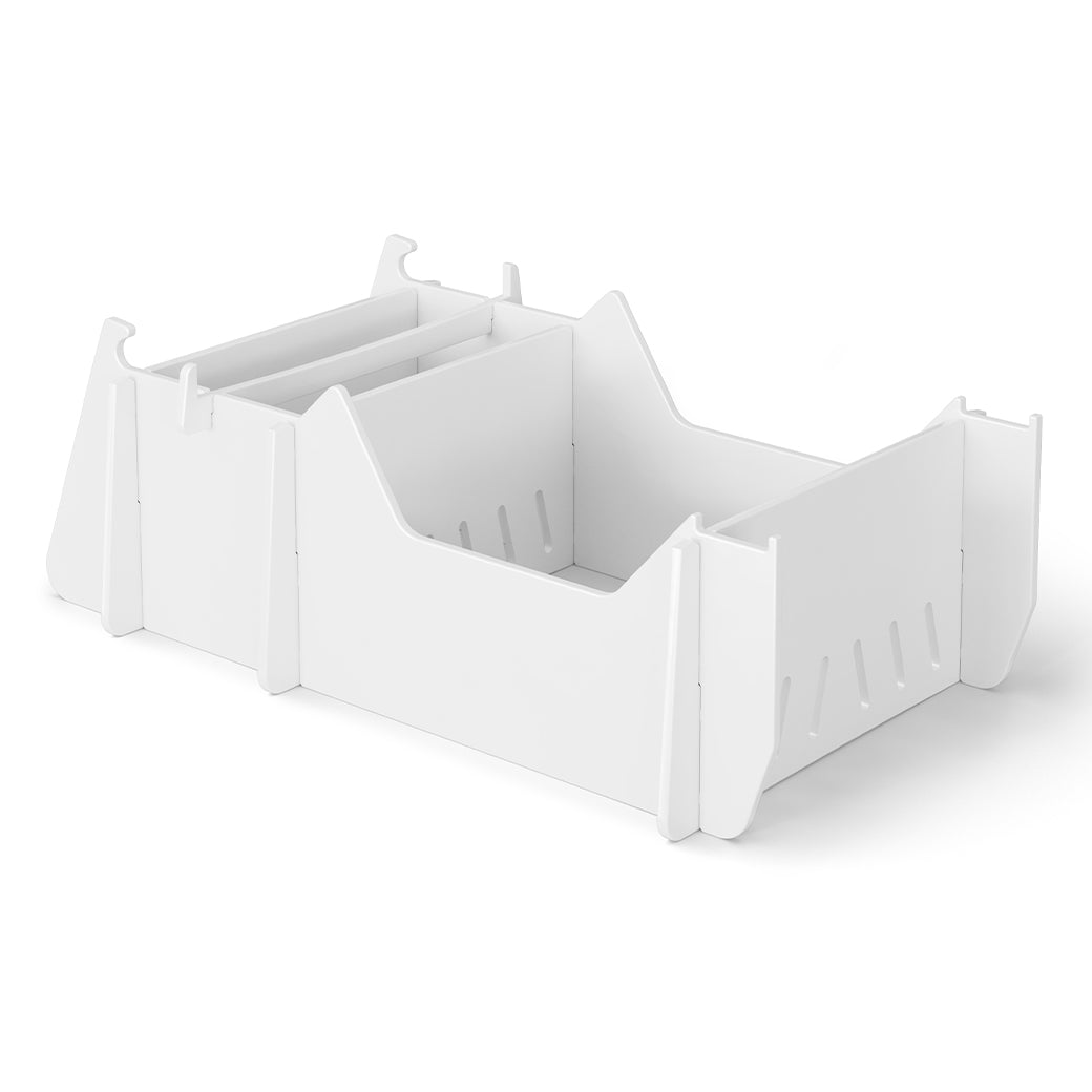 The Signature Chair Riser by Ledge Lounger is a white collapsible storage box with cut-out handles and interlocking panels for easy assembly and disassembly. It features slotted sides for ventilation and reinforcement, making it ideal for outdoor setups, all set elegantly on a plain white background.