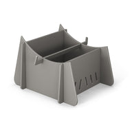 A Signature Chaise Riser by Ledge Lounger, featuring a gray plastic storage box with an angular design, sits on a white background. It has an open top, slotted sides, and a central divider, ideal for organizing outdoor essentials or storing in-pool seats.