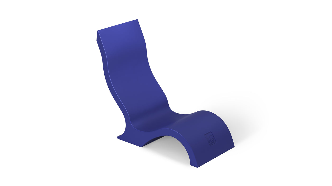 The Ledge Lounger Signature Chair is a modern, abstract piece featuring a curvy, S-like design in deep blue. Its durable construction offers a high backrest and wavy seat, making it ideal for stylish poolside seating against a plain white background.