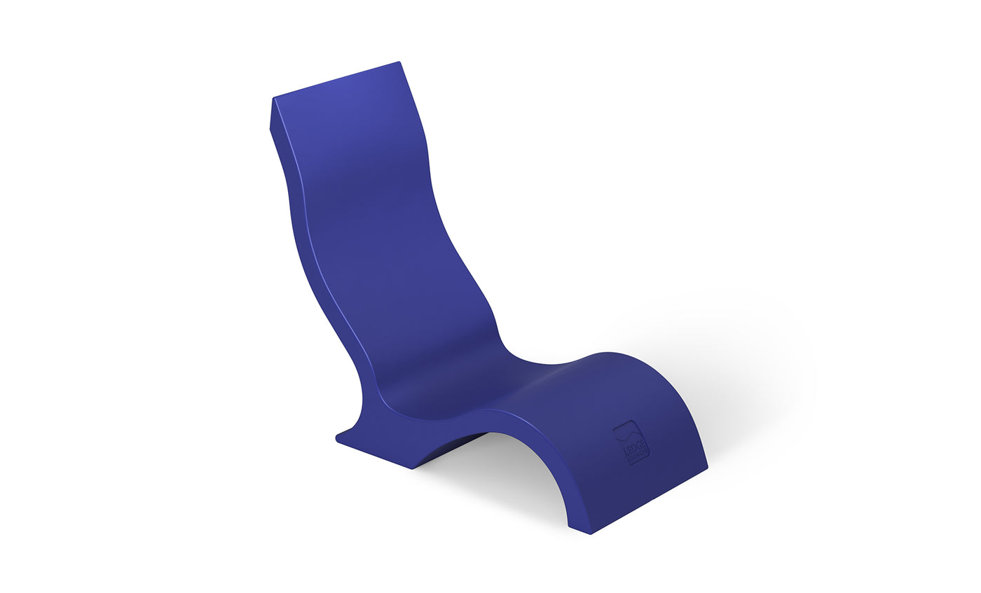 The Ledge Lounger Signature Chair With Short Riser features a sleek, ergonomic wave-shaped design in solid blue, offering stylish and comfortable poolside seating with smooth curves for a modern, sculptural look.