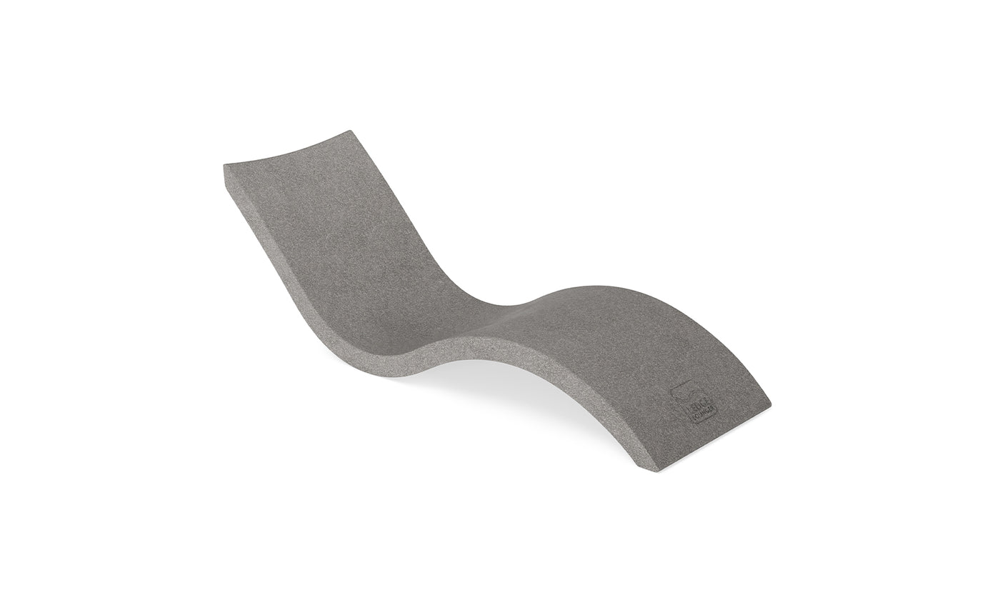 The Signature Chaise by Ledge Lounger is a modern, minimalist gray lounger featuring an ergonomic S-curve design and hidden legs, ideal for poolside relaxation, elegantly displayed on a plain white background.