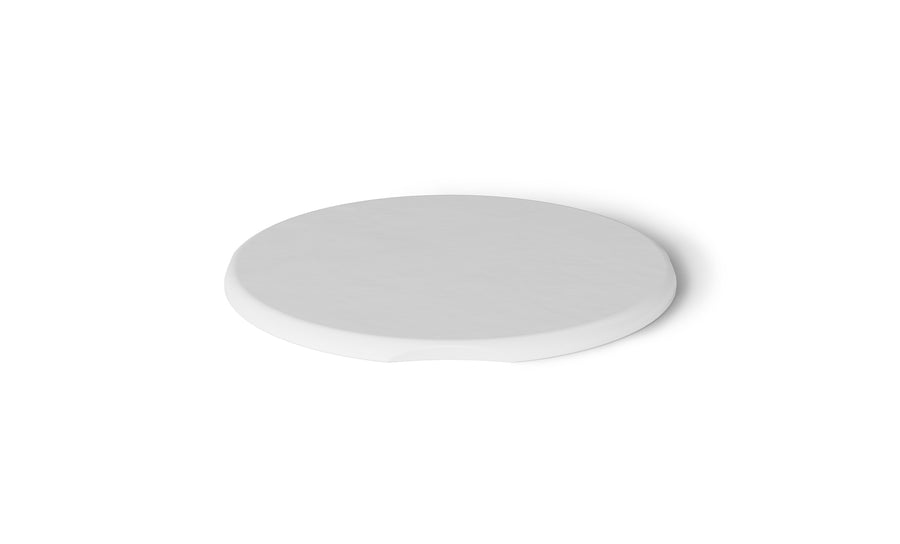 A round, flat, white coaster from Ledge Lounger mimicking the Signature Side Table Lid has a slight indentation on one side and is set against a plain white background.