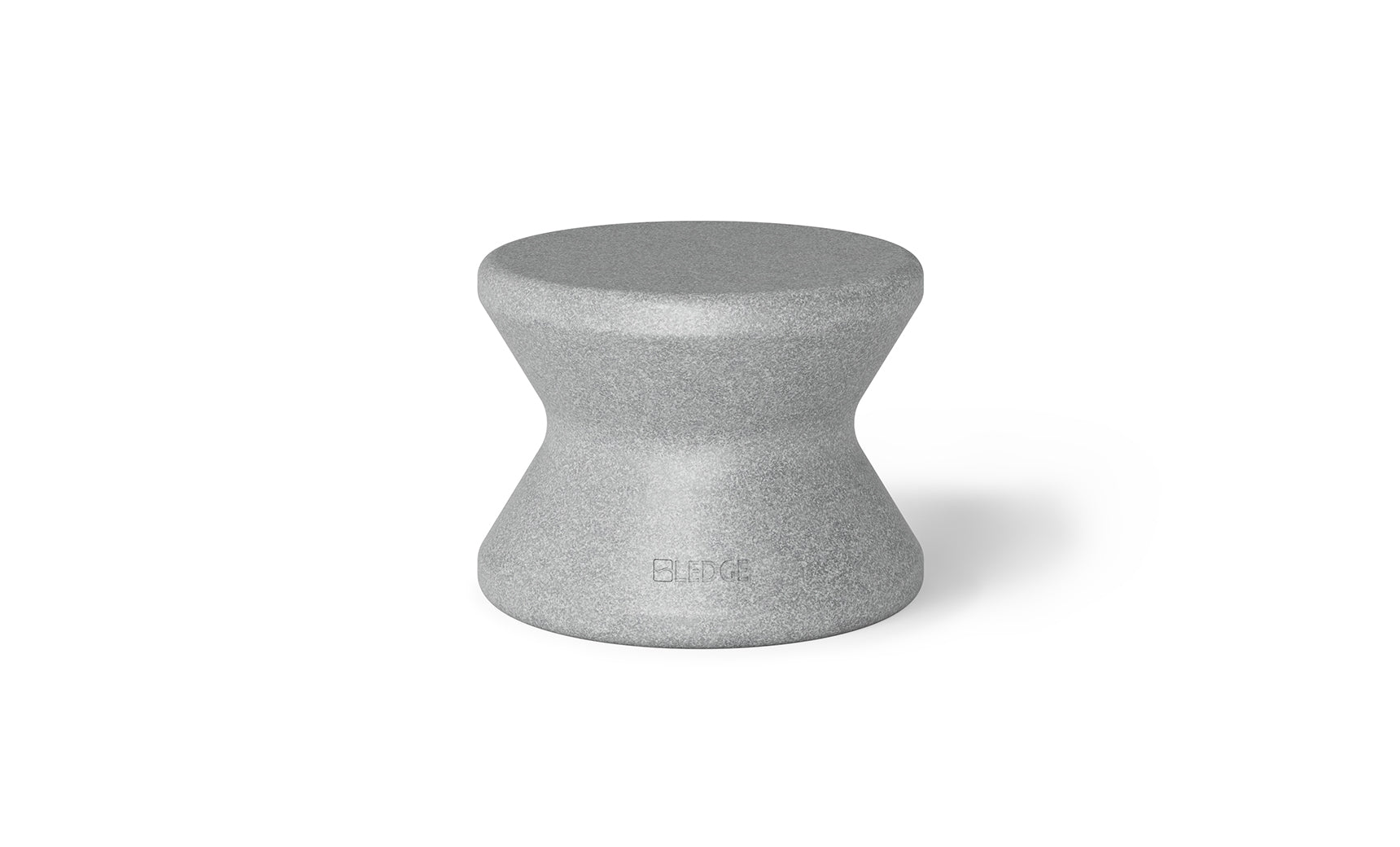 The Signature Standard Side Table by Ledge Lounger is a gray hourglass-shaped stool with a textured surface and smooth, curved design, perfect for in-pool use. The name BLØK is subtly engraved near the base, set against a plain white background.