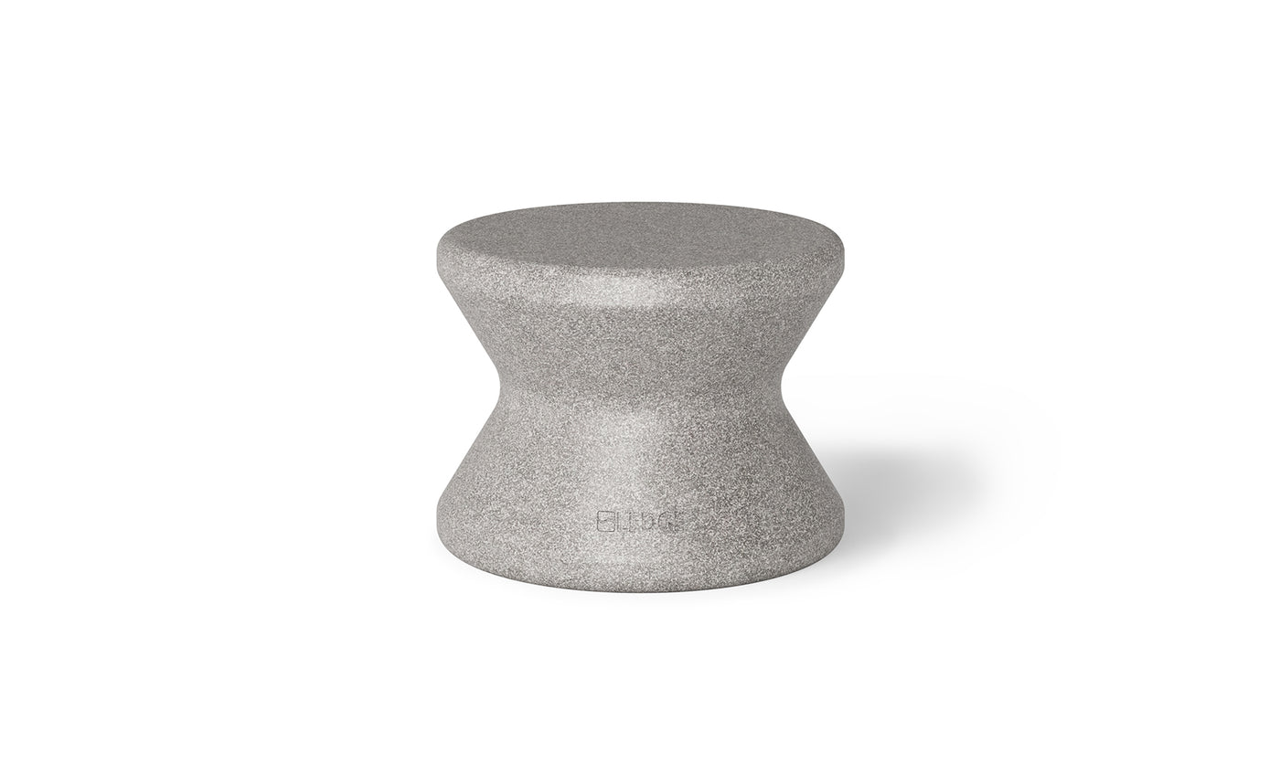 The Signature Standard Side Table by Ledge Lounger is a gray hourglass-shaped stool with a smooth surface, ideal for in-pool use. It complements any sun shelf setting and is set against a plain white background.