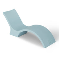 The Signature Chaise Deep by Ledge Lounger is a light blue, modern chaise lounge with a smooth, curved design and an elevated backrest. Perfect for a sun shelf or tanning ledge, its showcased against a white background for ultimate relaxation.