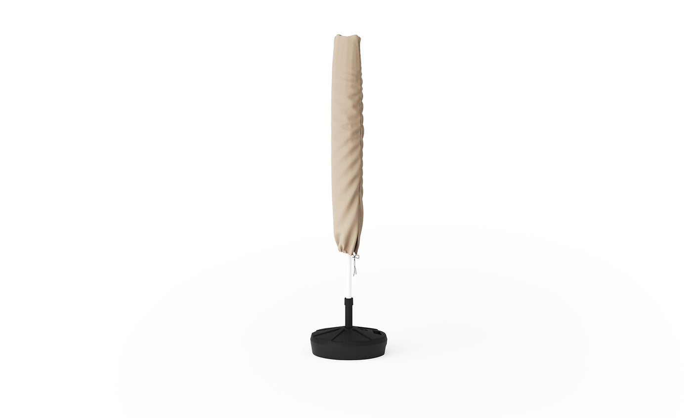A closed Signature Umbrella Cover by Ledge Lounger stands upright with a protective cover in a black weighted base on a white background.
