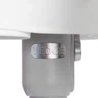 A close-up of a cylindrical metal component embossed with LEDCE evokes the durability of wind-resistant umbrellas. Connected to a larger white structure, it boasts a smooth light gray surface, reminiscent of the 6.5 Square Signature 360° Tilt Umbrella by Ledge Lounger.