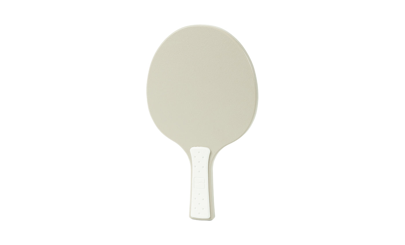 A table tennis paddle by Ledge Lounger is shown against a plain white background, featuring a beige plastic design with a textured oval surface and a short handle.