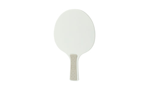 The Table Tennis Paddle by Ledge Lounger features a white plastic surface and a beige textured handle, resembling a traditional table tennis paddle, shown against a plain white background.