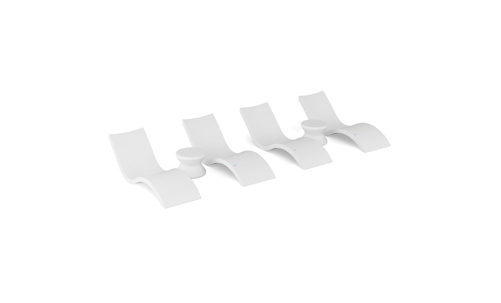 Four identical Signature Chaise and Side Table In-Pool 6-Piece Sets by Ledge Lounger, with sleek curved forms, are arranged in a row on a white background, evoking the minimalist elegance of resort poolside furniture.