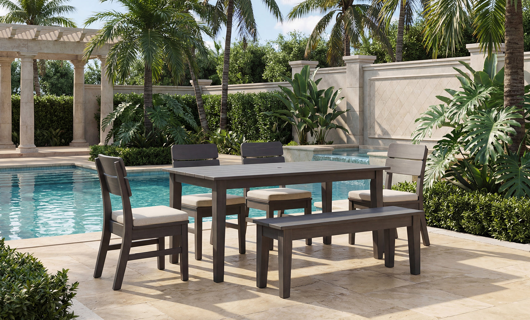 Experience the perfect blend of comfort and contemporary style with the Ledge Lounger Mainstay Dining 9-Piece Patio Set—a stunning sample product for your patio. This elegant arrangement includes four chairs and a bench, beautifully set on a stone patio beside the pool and framed by vibrant tropical plants and swaying palm trees. The Mainstay Dining Set offers a modern outdoor dining experience, ideal for relaxing al fresco gatherings.