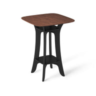The Haven Hightop Table by Ledge Lounger is a modern, square piece featuring a dark wood top and black curved legs for ergonomic comfort. Its durable design includes a matching lower shelf, making it sleek and contemporary—ideal for any stylish patio collection.