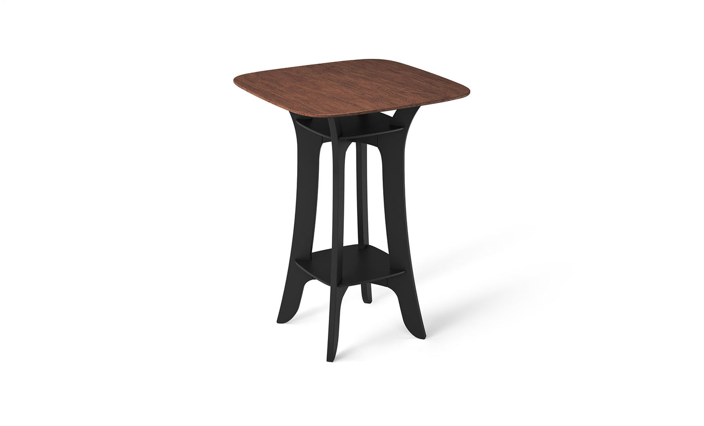 The Haven Hightop Table by Ledge Lounger is a modern, square piece featuring a dark wood top and black curved legs for ergonomic comfort. Its durable design includes a matching lower shelf, making it sleek and contemporary—ideal for any stylish patio collection.