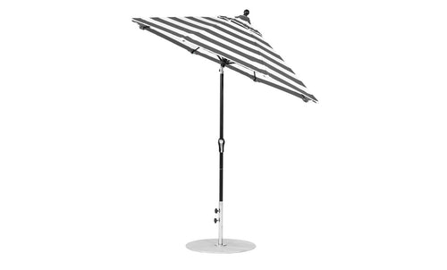 The Essential Fiberglass Umbrella - 7.5 Octagon Crank Auto Tilt by Ledge Lounger features a black and white striped design with marine-grade fabrics, an adjustable pole, and a round metal base. This wind-resistant umbrella boasts sturdy construction and a classic tilted design.