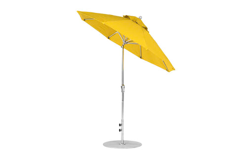 The Ledge Lounger Essential Fiberglass Umbrella, 7.5 octagon with crank auto tilt, features a bright yellow marine-grade fabric canopy on a silver pole and round metal base. Its open and slightly tilted, showcasing its durable design.