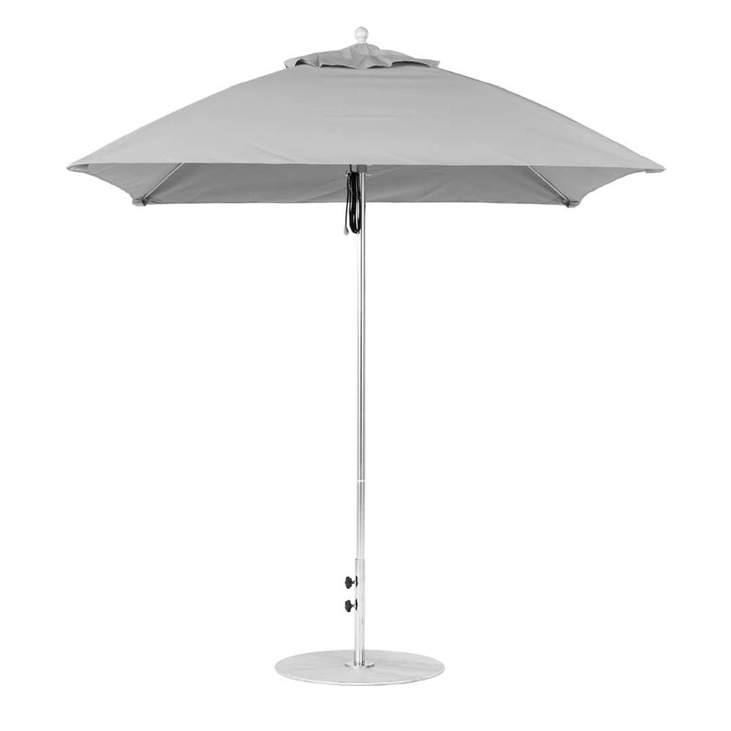 The Essential Fiberglass Umbrella by Ledge Lounger features a silver pole and marine-grade gray canopy, mounted on a circular base, isolated on a white background.