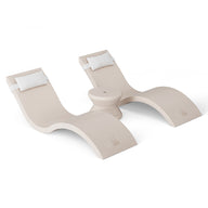 The Outdoor Paradise In-Pool Furniture Bundle by Ledge Lounger features two beige, wavy lounge chairs with integrated headrests linked by a circular table. Set against a white backdrop, these modern chaise loungers craft an inviting oasis for your space.