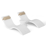 The Outdoor Paradise In-Pool Furniture Bundle by Ledge Lounger features two modern white loungers with beige headrests, connected by a small round table. Their sleek, wavy design creates an exquisite and serene escape against a plain white background.