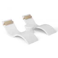 The Outdoor Paradise In-Pool Furniture Bundle by Ledge Lounger includes two sleek, white chaise loungers with tan head cushions and a small central table, all featuring a modern curved design.