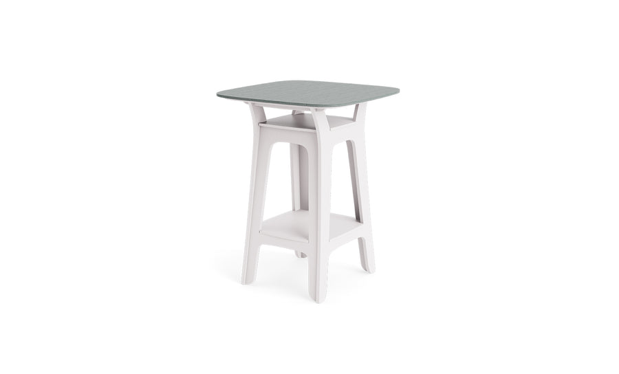 The Haven Hightop Table by Ledge Lounger features a modern, square light grey top, white angled legs, and a lower storage shelf. Its minimalist design brings contemporary style to any outdoor area.