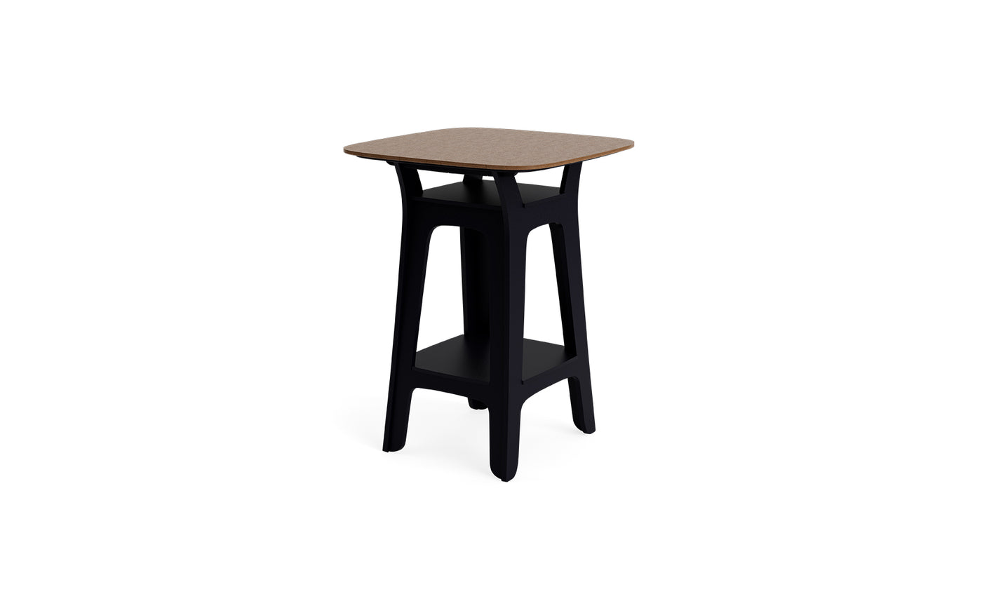 The Haven Hightop Table by Ledge Lounger features a square wooden top, black angled legs, and a lower storage shelf—a modern side table ideal for enhancing your outdoor space.