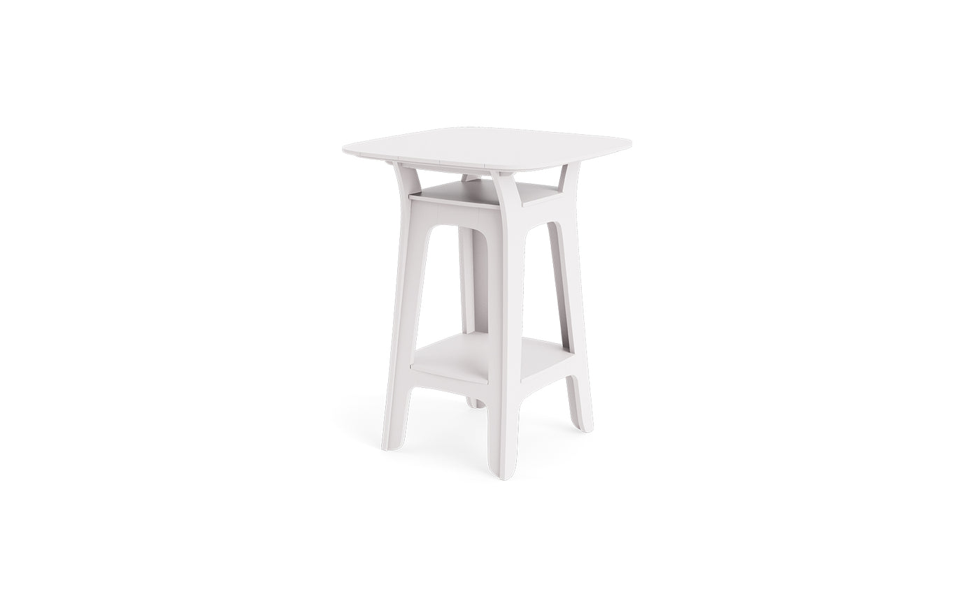 The Ledge Lounger Haven Hightop Table is a modern, small white side table with a square top, curved legs, and a lower storage shelf from the Haven Hightop Collection, shown against a plain white background.